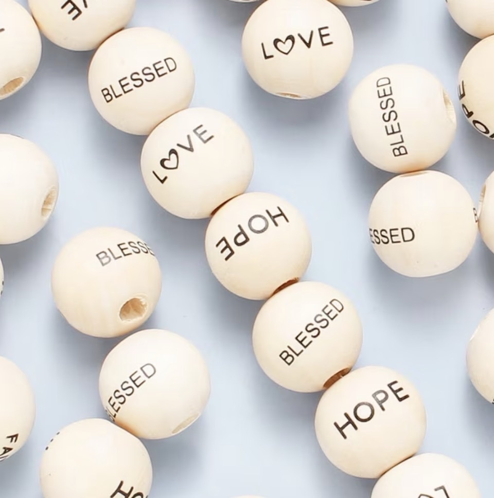 Natural wood beads printed with the words Blessed, Love, and Hope