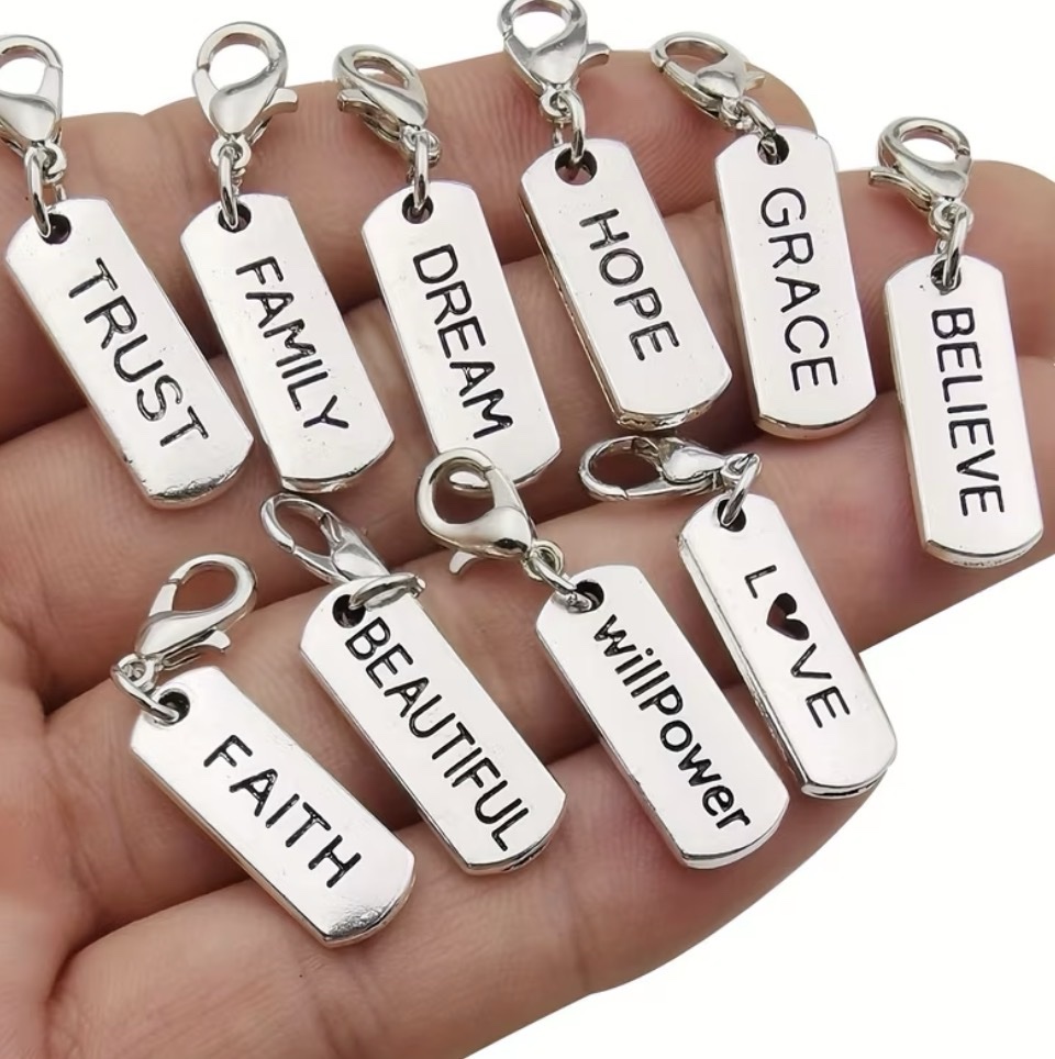 Silver charms with words including Trust, Family, Dream, Hope, Grace, Believe, Faith, and Love